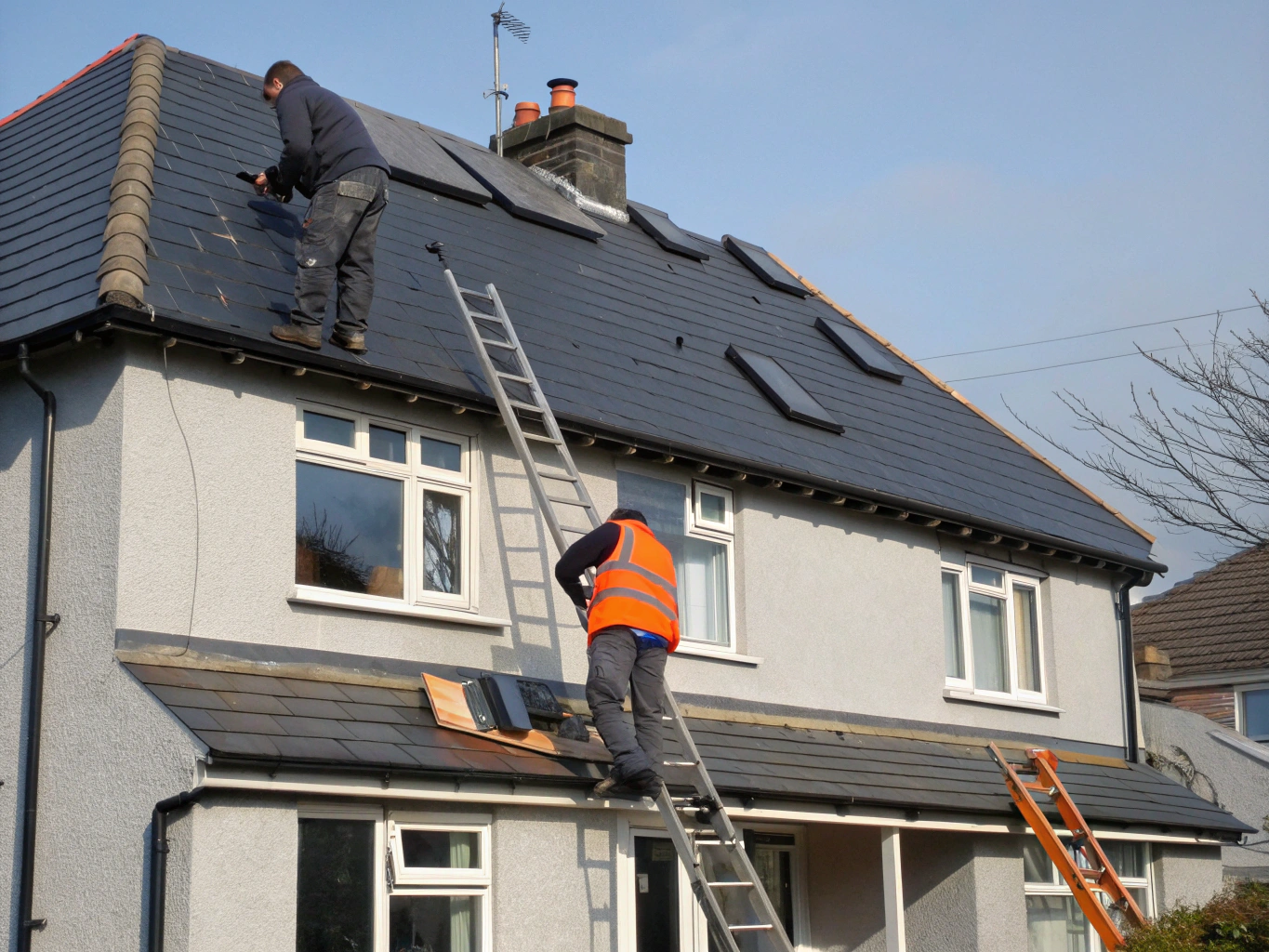 UK roofing crew installing slate tiles on scaffolding-supported roof